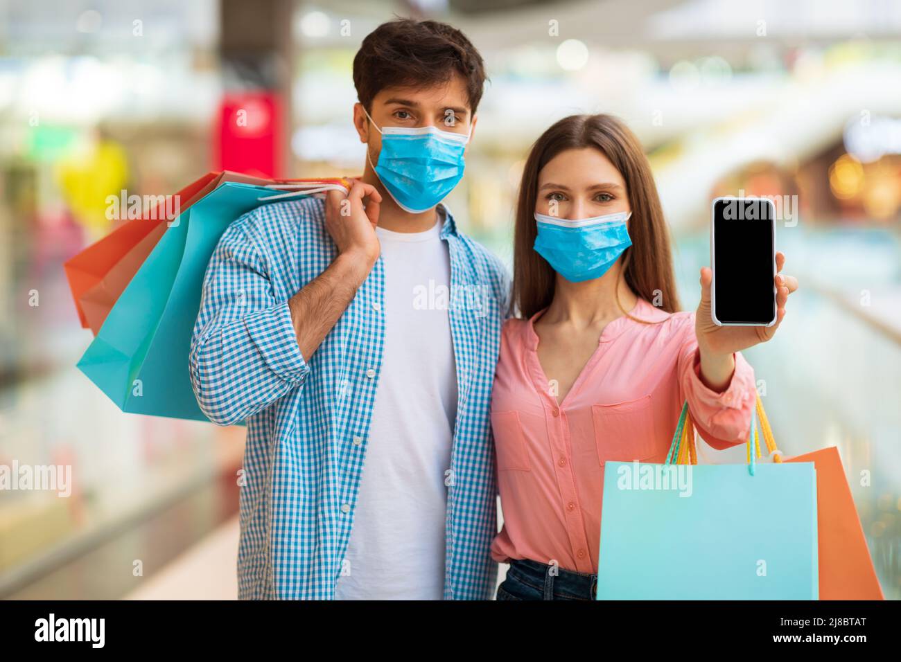 Coppia che mostra la schermata Telefono per l'annuncio dell'applicazione di Shopping in Mall Foto Stock