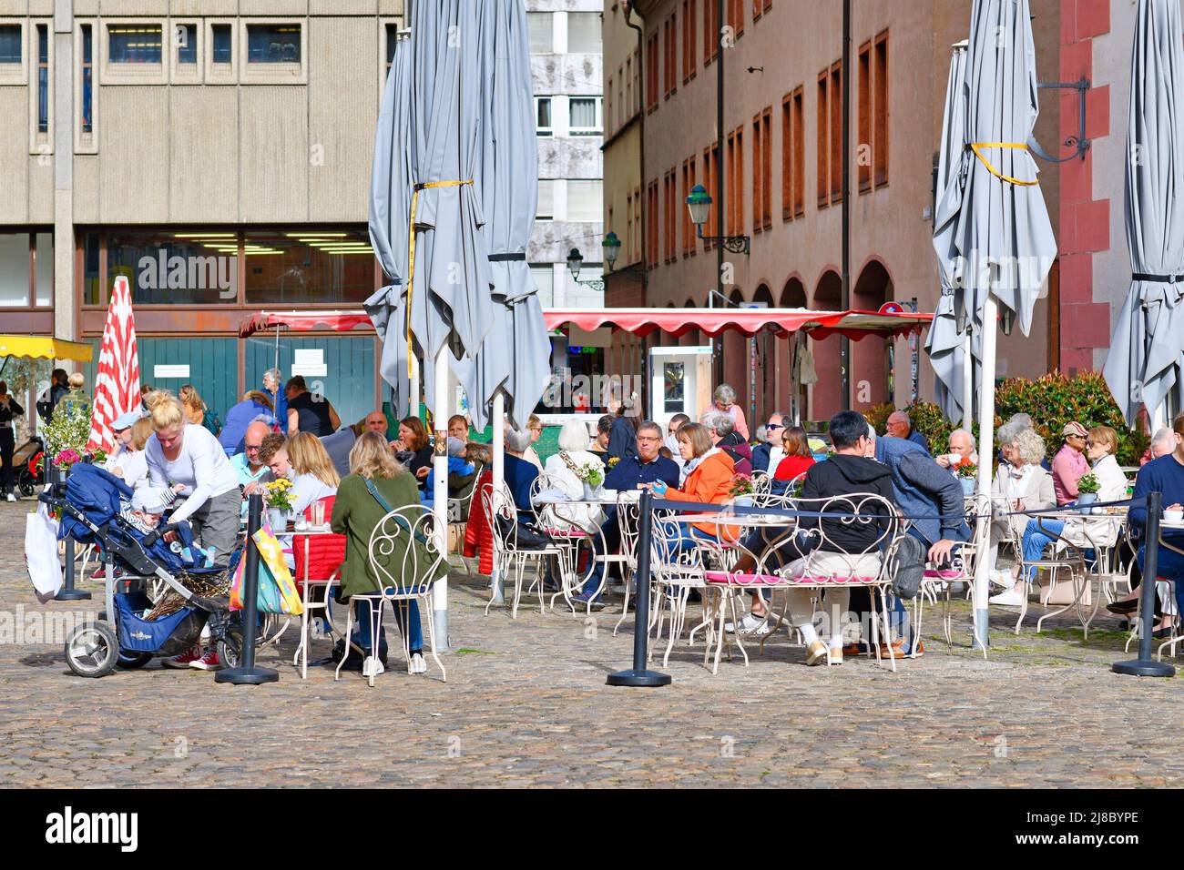 Friburgo, Germania - Aprile 2022: Persone che si rilassano in bar all'aperto in giornata di sole Foto Stock