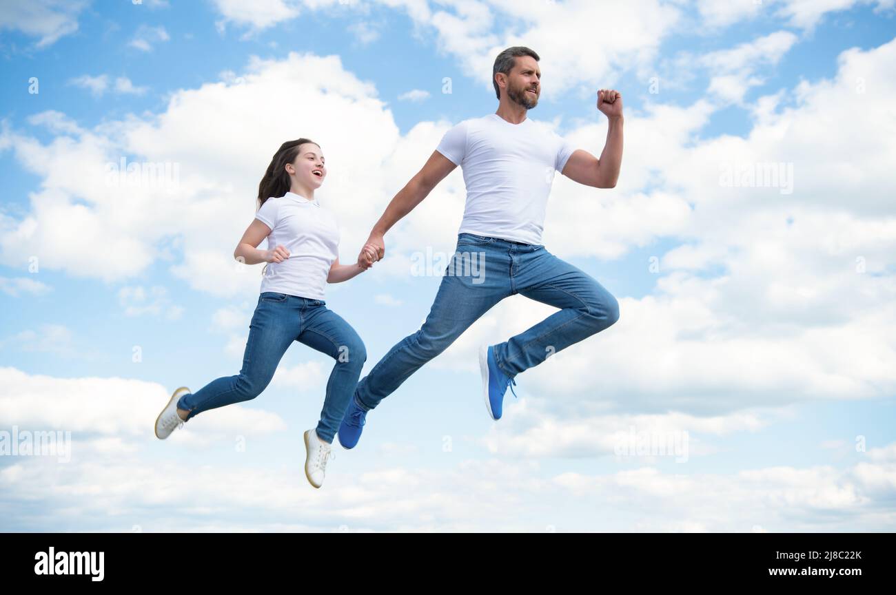 padre e figlia energici saltano nel cielo Foto Stock