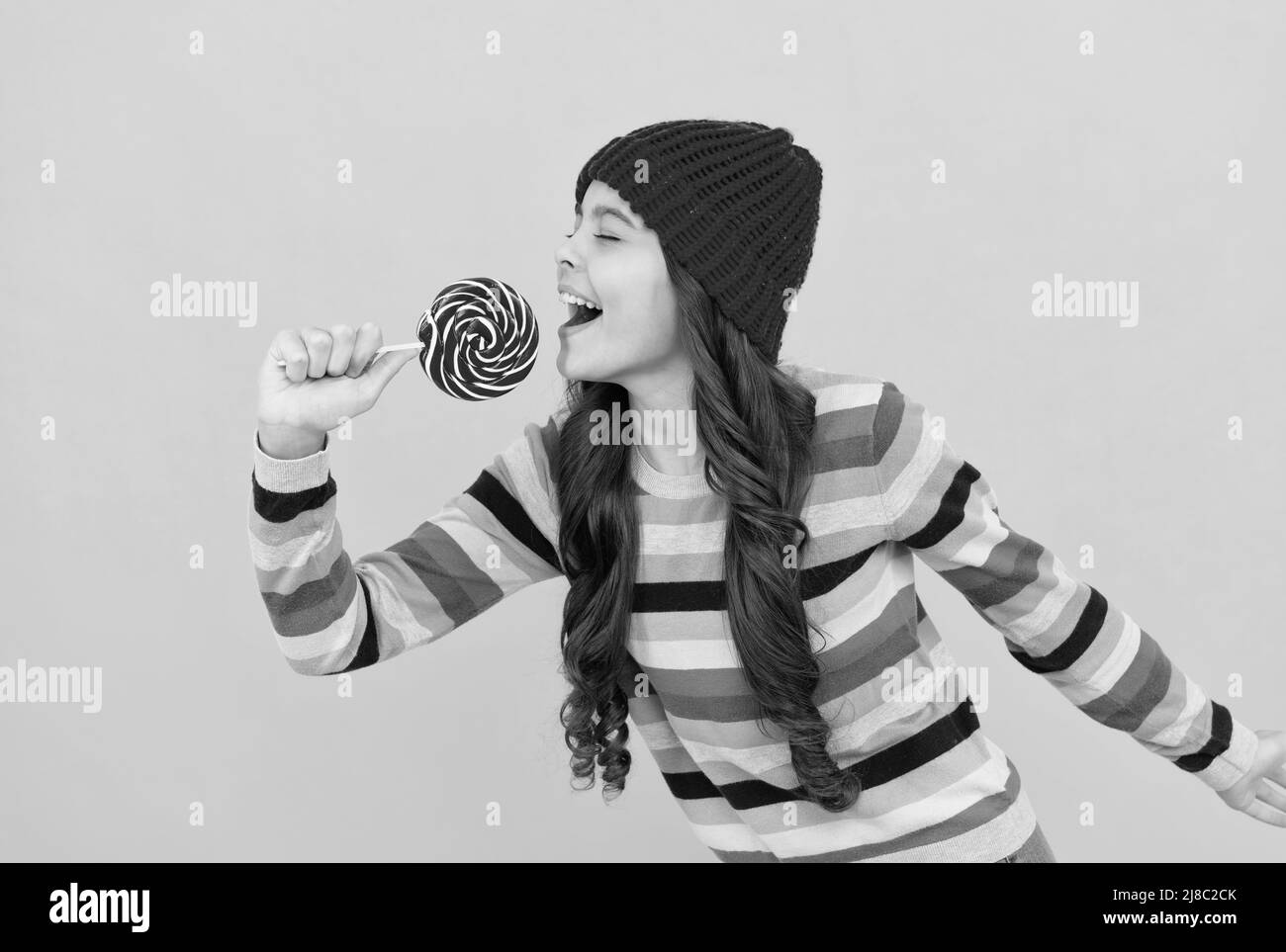 felice ragazza capretto tenere lollipop dolce, divertente Foto Stock