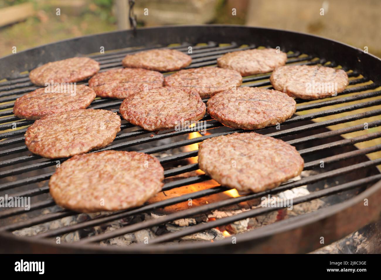 Hamburger alla griglia su un barbecue nel giardino Foto Stock