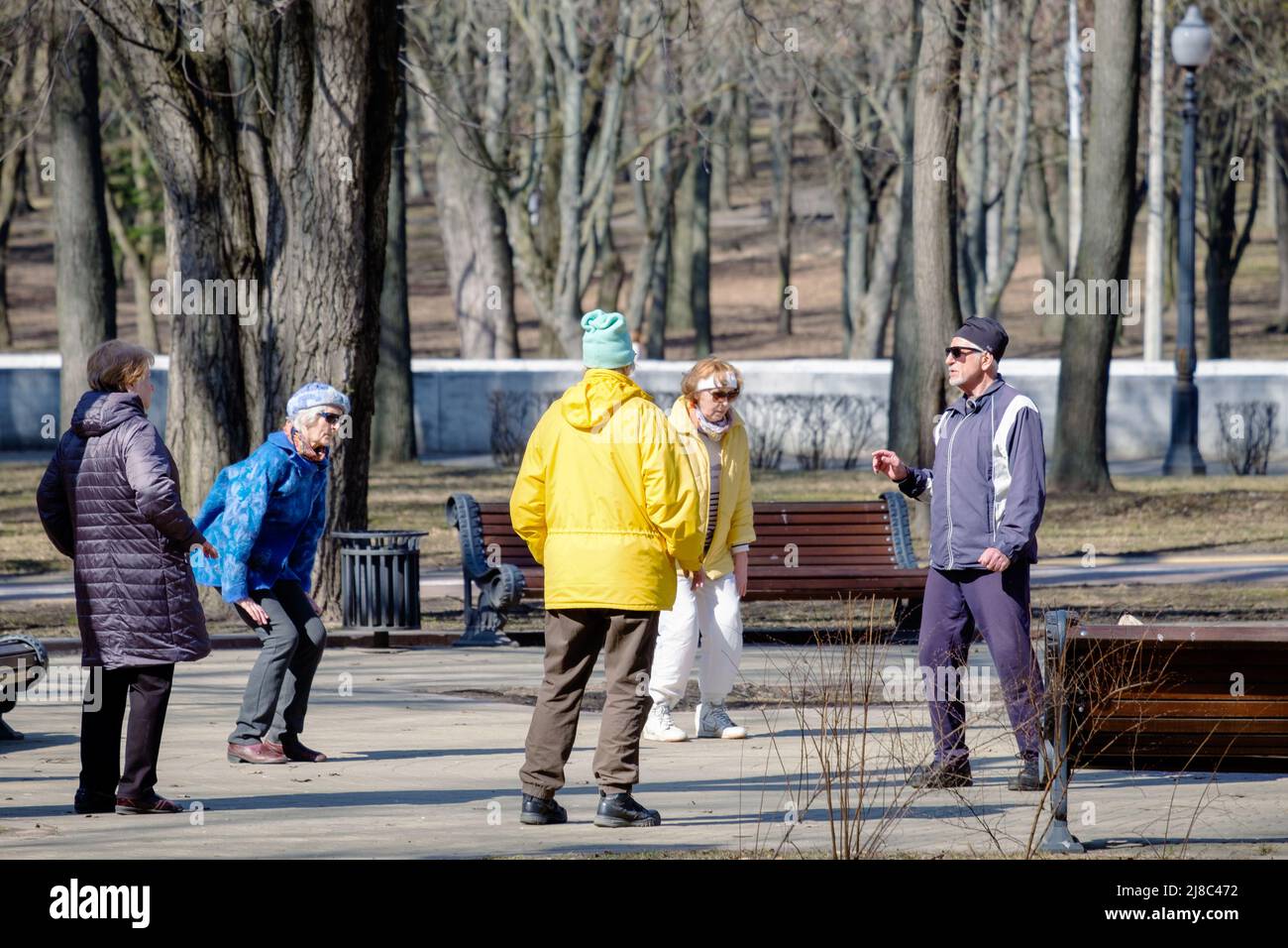 Minsk, Bielorussia - 25 marzo 2022: Gli anziani fanno esercizi respiratori nel parco. Anziani attivi Foto Stock