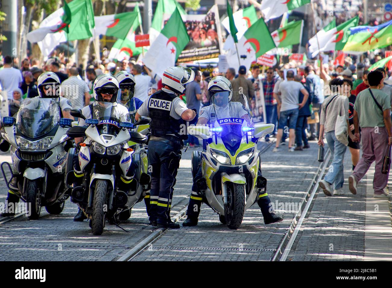 Gli agenti di polizia si levano in guardia durante la dimostrazione. Centinaia di membri della diaspora algerina marciano a Marsiglia contro la dittatura militare nel loro paese. Foto Stock