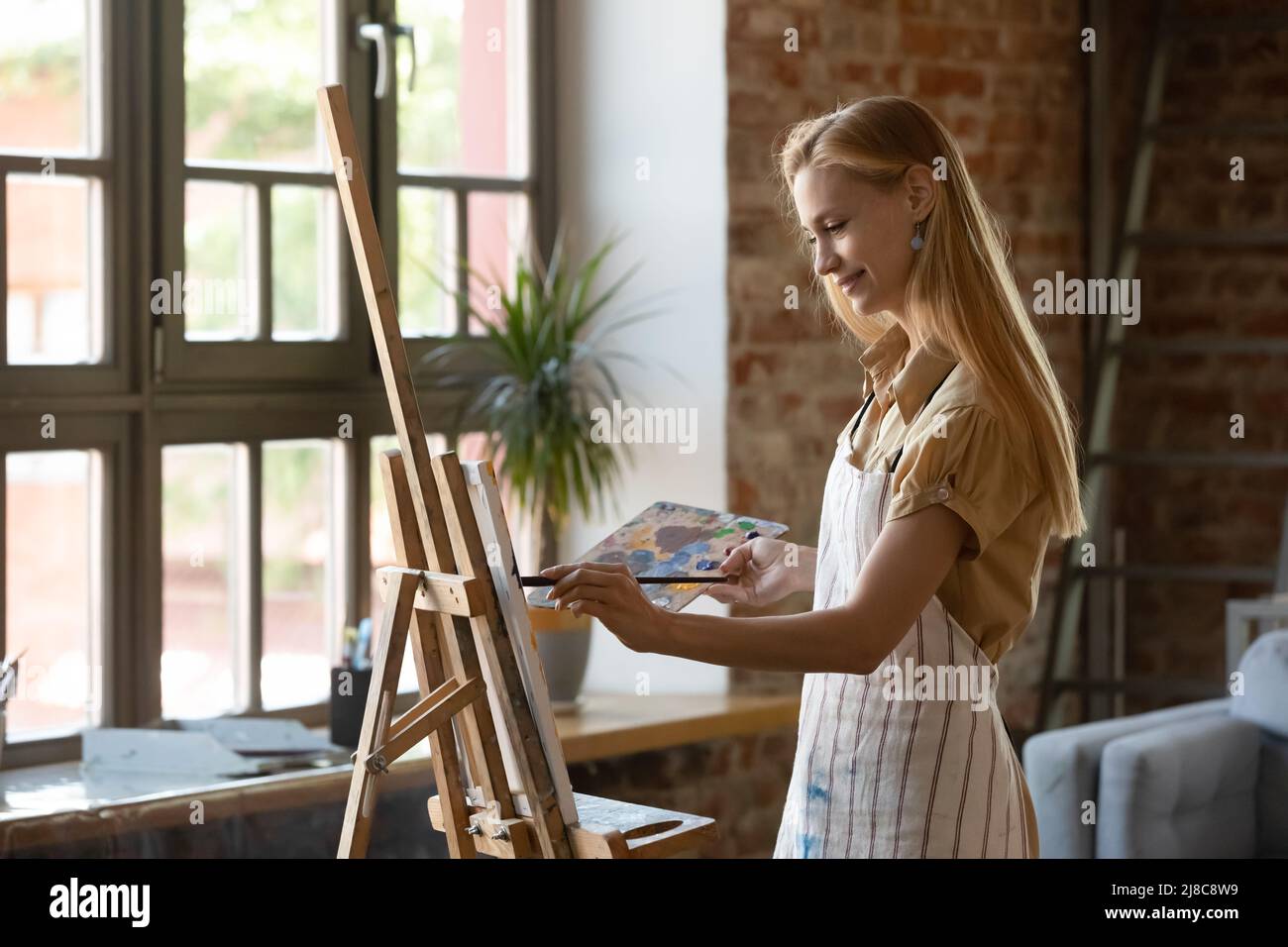 Pittore donna pittura immagine su tela sorrisi godere di hobby creativo Foto Stock