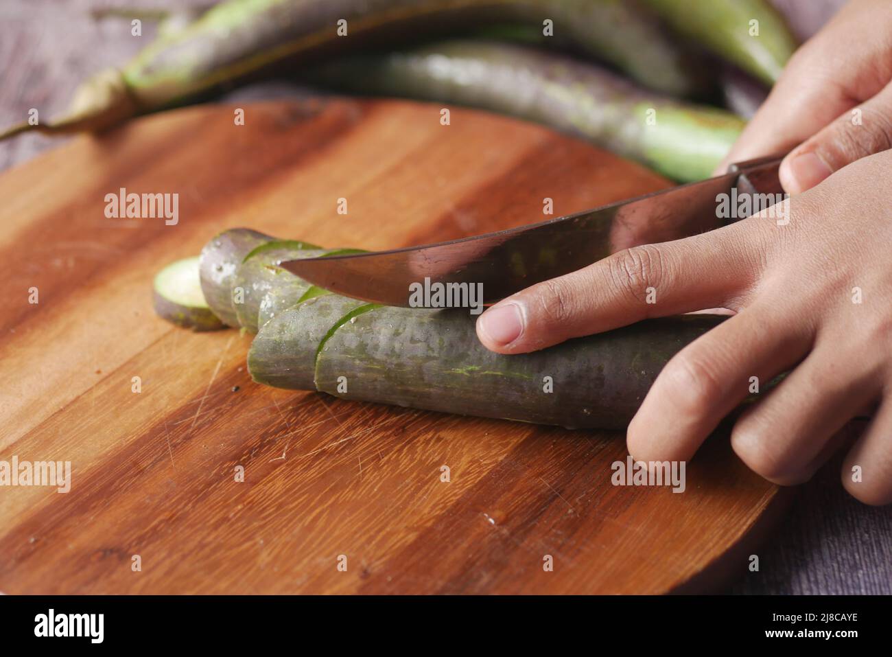 tagliando melanzane su un tagliere Foto Stock