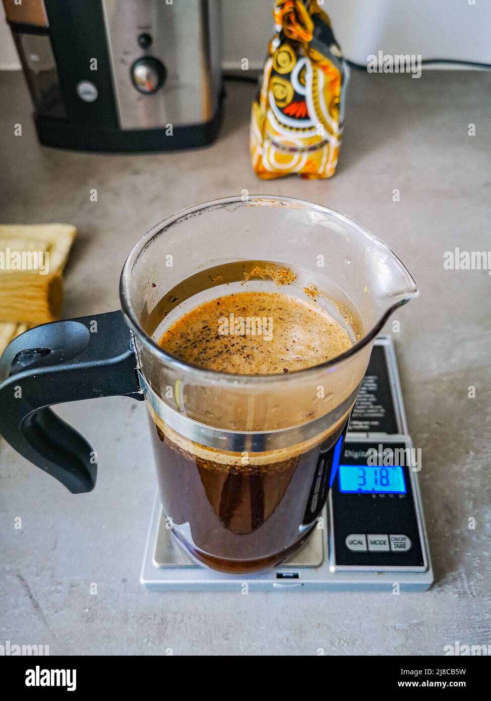 Piccola caraffa di caffè su un piccolo peso elettronico Foto Stock