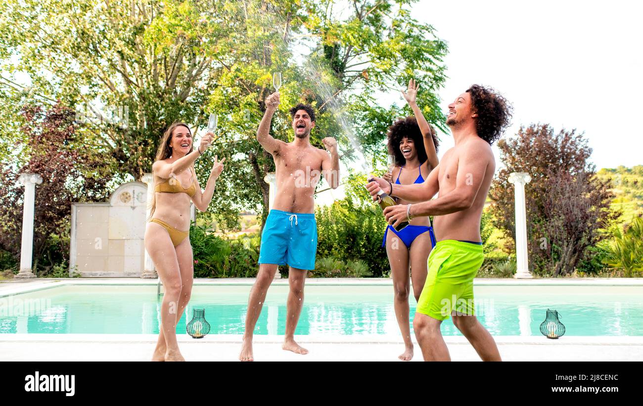 festa estiva in piscina! felice gruppo di amici multirazziale che beve vino  al party in piscina ballando sulla doccia con champagne per celebrare  l'estate Foto stock - Alamy