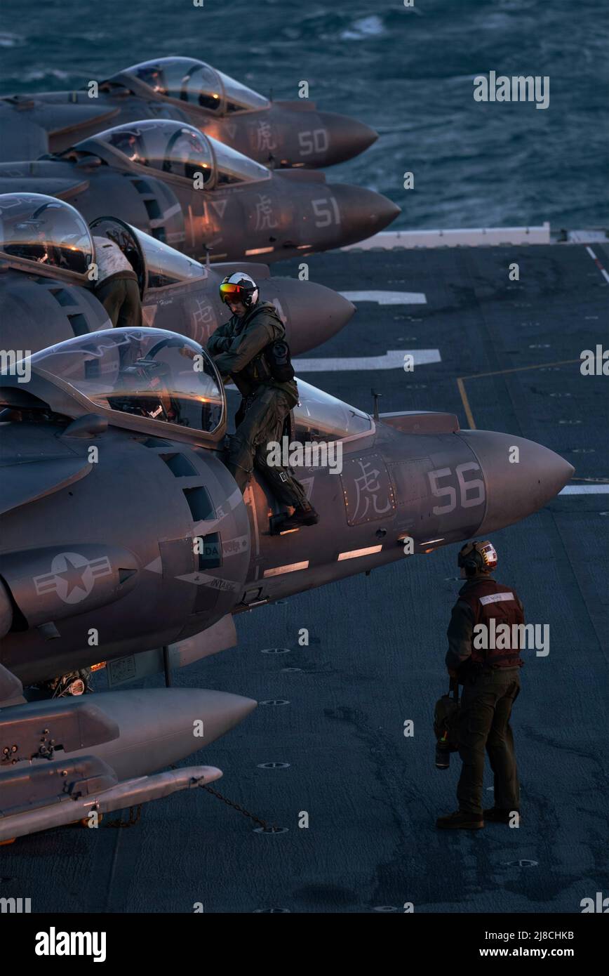 I piloti del corpo Marino degli Stati Uniti preparano i loro velivoli da combattimento AV-8B Harrier attaccati al Tigers of Marine Attack Squadron 542, per il lancio sul ponte di volo della nave d'assalto anfibio di classe Wasp USS Kearsarge, 25 gennaio 2022 che opera sull'Oceano Atlantico. Foto Stock