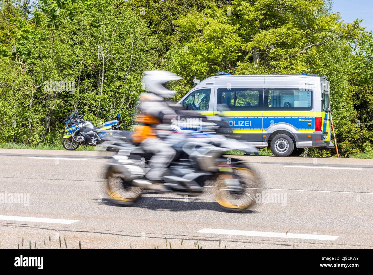 15 maggio 2022, Baden-Wuerttemberg, Pforzheim: Un motociclista passa davanti a un checkpoint della polizia. La sede della polizia di Pforzheim sta effettuando oggi un controllo motociclistico su larga scala sul B500 nel distretto di Freudenstadt. Foto: Philipp von Ditfurth/dpa Foto Stock