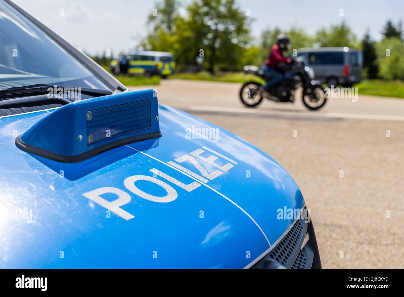 15 maggio 2022, Baden-Wuerttemberg, Pforzheim: Un motociclista passa davanti a un checkpoint della polizia. La sede della polizia di Pforzheim sta effettuando oggi un controllo motociclistico su larga scala sul B500 nel distretto di Freudenstadt. Foto: Philipp von Ditfurth/dpa Foto Stock