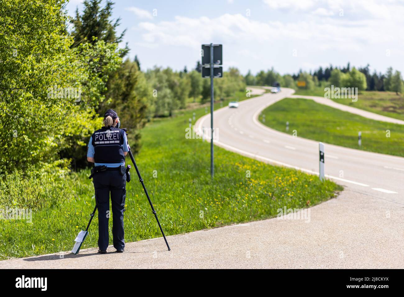 15 maggio 2022, Baden-Wuerttemberg, Pforzheim: Un poliziotto misura la velocità di un'auto in avvicinamento. La sede della polizia di Pforzheim sta effettuando oggi un controllo motociclistico su larga scala sul B500 nel distretto di Freudenstadt. Foto: Philipp von Ditfurth/dpa Foto Stock