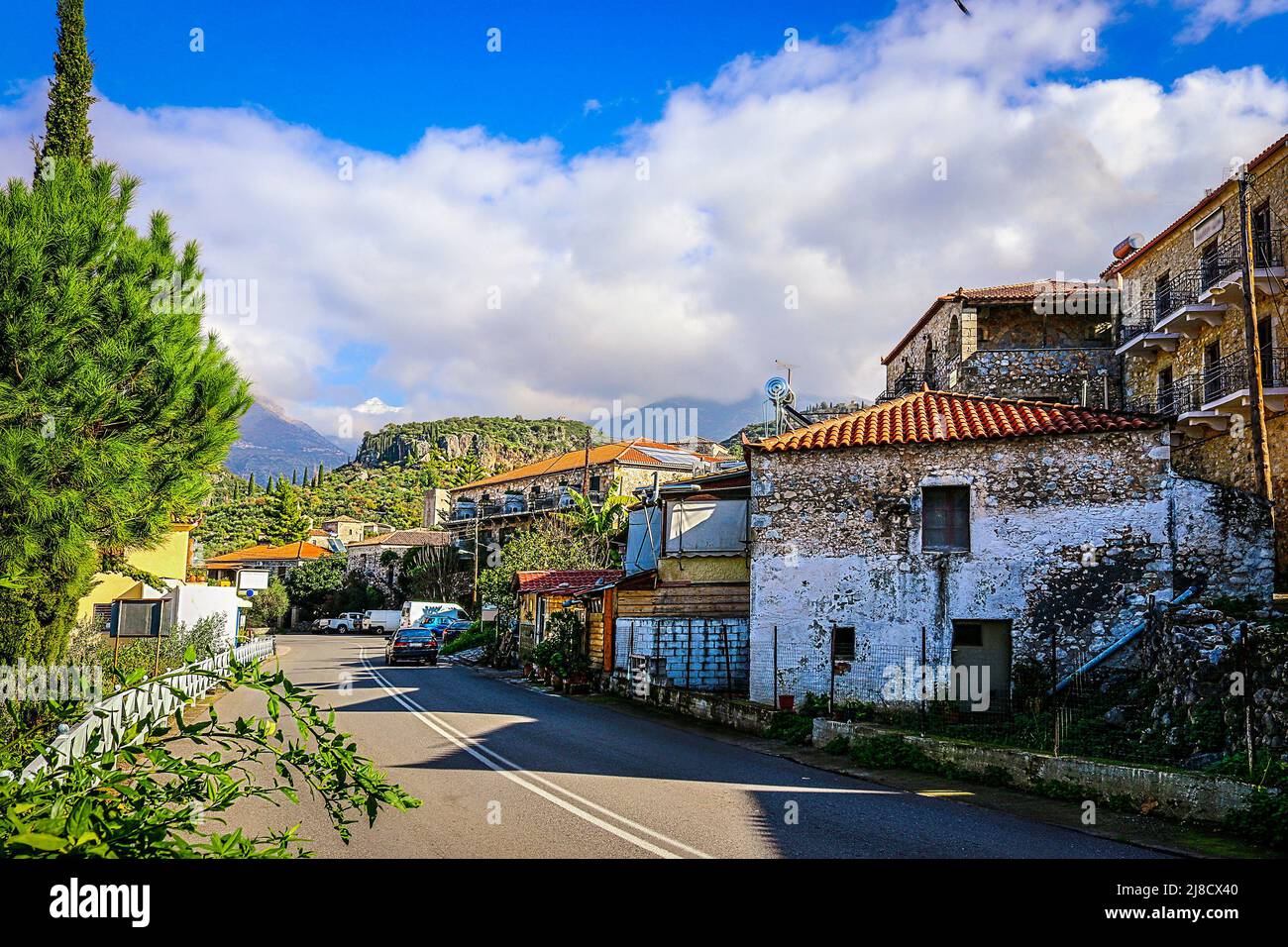 Scena stradale a Kardamili Grecia sotto il Monte Taygetus sulla penisola di mani sul Peloponneso - edifici rustici con tetti di tegole sono costruiti su collina Foto Stock