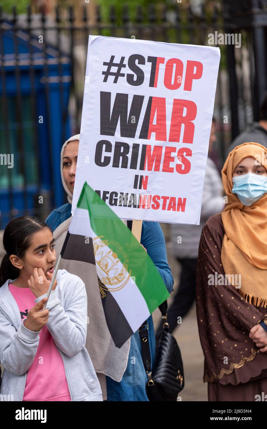 Whitehall, Westminster, Londra, Regno Unito. 15th maggio 2022. I manifestanti stanno dimostrando a Londra contro le azioni dei talebani sulle questioni dei diritti umani in Afghanistan a seguito della partenza delle forze militari occidentali. Donna con STOP ai crimini di guerra in Afghanistan cartello Foto Stock