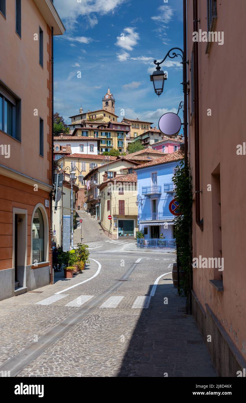 Monforte d'Alba, langhe, Italia: Vista del borgo medievale sulla collina con l'antico campanile e caratteristici edifici colorati su cielo blu e. Foto Stock