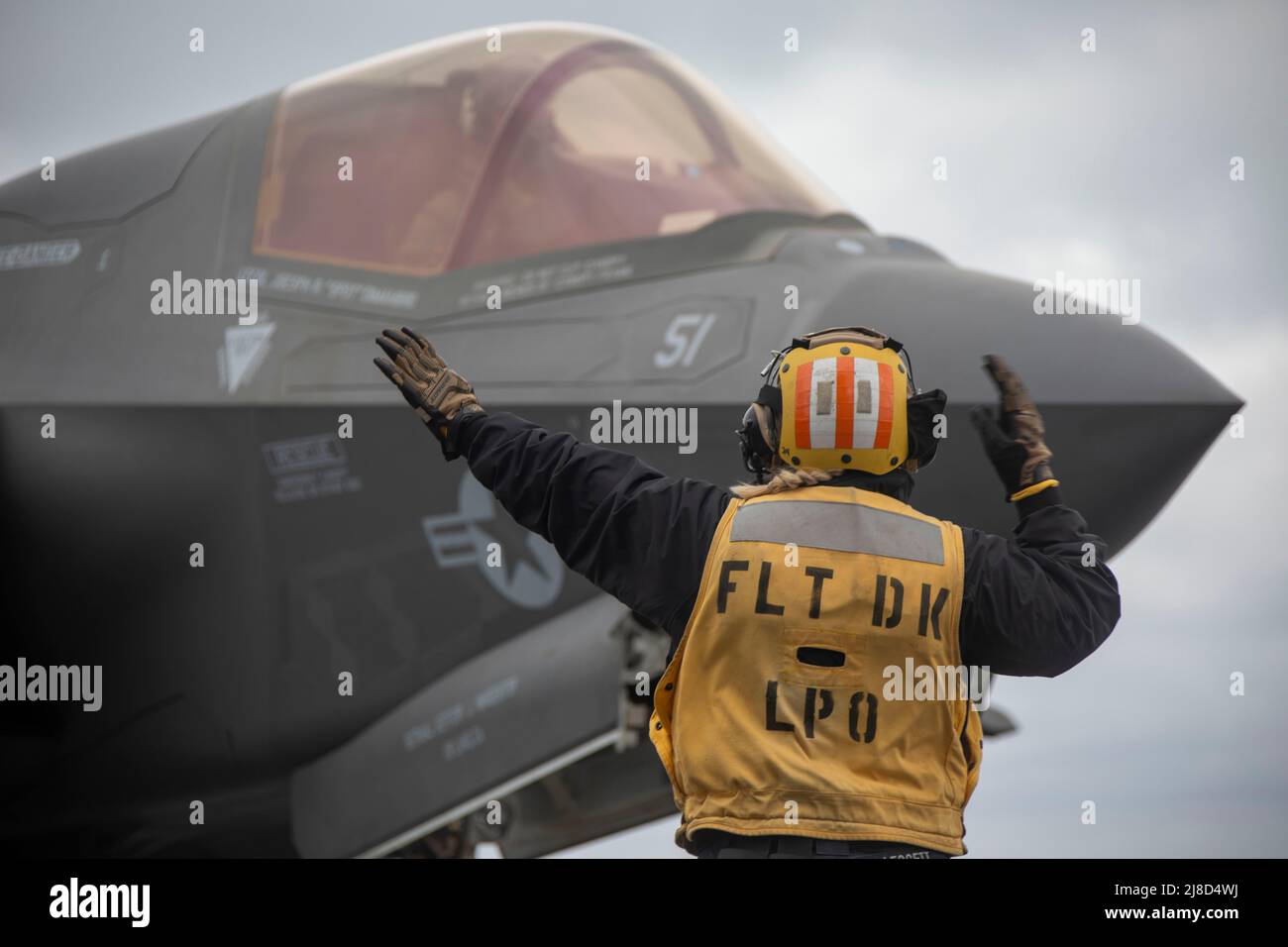 U.S. Navy Aviation Boatswains Mate 1st Classe Jenna Leggett dirige un aereo da caccia U.S. Marine Corps F-35B Lightning II, attaccato ai Knightriders of Marine Medium Tiltrotor Squadron 164, dopo l'atterraggio sul ponte di volo della nave d'assalto anfibio di classe Wasp USS Makin Island durante l'operazione Northern Edge 2021, Maggio 7, 2021 che opera sul Golfo dell'Alaska. Foto Stock