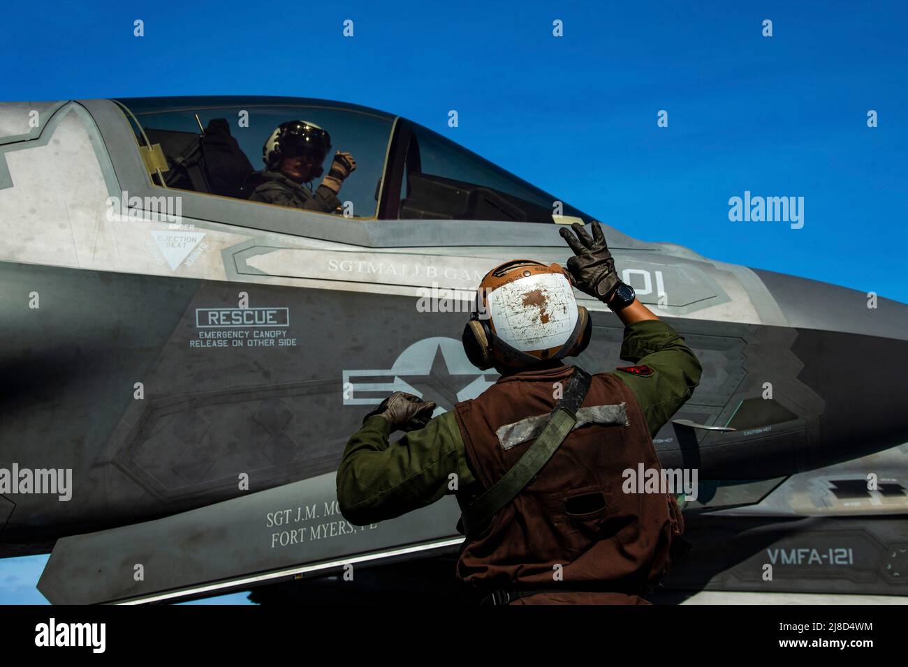 Un velivolo da caccia U.S. Marine Corps F-35B Lightning II, attaccato ai draghi di Marine Medium Tiltrotor Squadron 265, è segnalato per il lancio dal ponte di volo della nave d'assalto anfibio di classe americana USS America, 23 marzo 2020 che opera sul Mare delle Filippine. Foto Stock