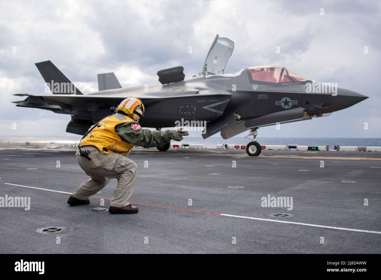 U.S. Navy Senior Chief Aviation Boatswains Mate Mercedes Amador dirige un aereo da caccia del corpo Marino F-35B Lightning II, attaccato ai draghi del Medio Tiltrotor Squadron 264, per lanciare dal ponte di volo della nave d'assalto anfibio di classe americana USS America, 9 gennaio 2021 che opera sul Mare delle Filippine. Foto Stock