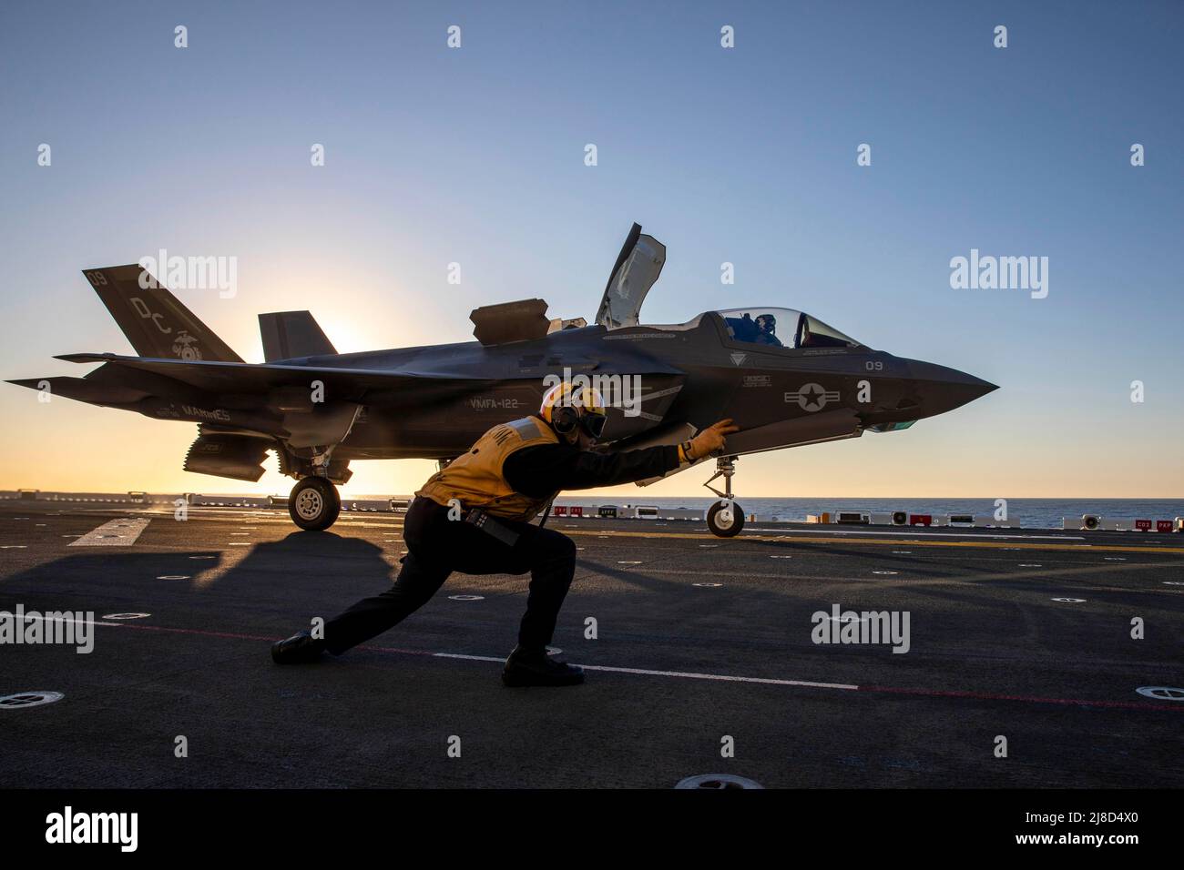 U.S. Navy Aviation Boatswains Mate 1st Class Fidel Colin segnala un aereo da caccia del corpo Marino F-35B Lightning II, attaccato ai Letherneck volanti dell'attacco del Combattente Marino Squadron 122, per lanciare dal ponte di volo della nave d'assalto anfibio di classe Wasp USS Makin Island, febbraio 2, 2022 operare sull'Oceano Pacifico. Foto Stock