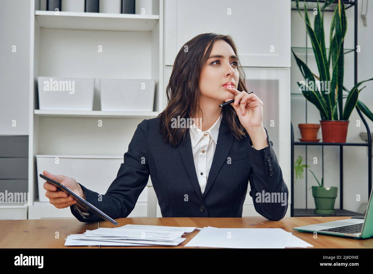 pensieroso bella giovane donna d'affari adulto manager in un vestito con un tablet pc in ufficio imprenditore Foto Stock