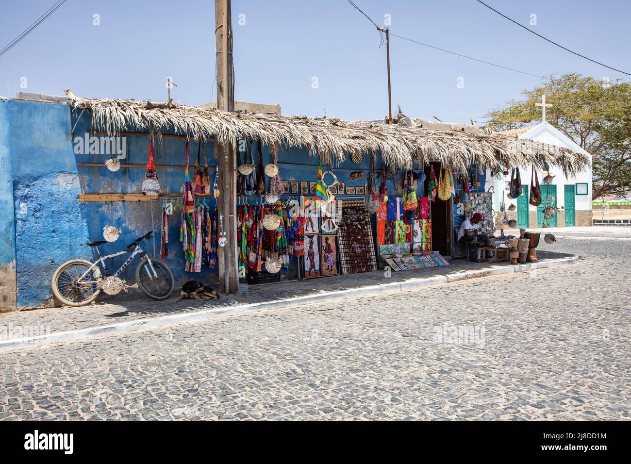 Negozio tradizionale che vende souvenir con la chiesa di Capela de Sao Jose sullo sfondo, Palmeira, SAL, Isole di Capo Verde, Africa Foto Stock
