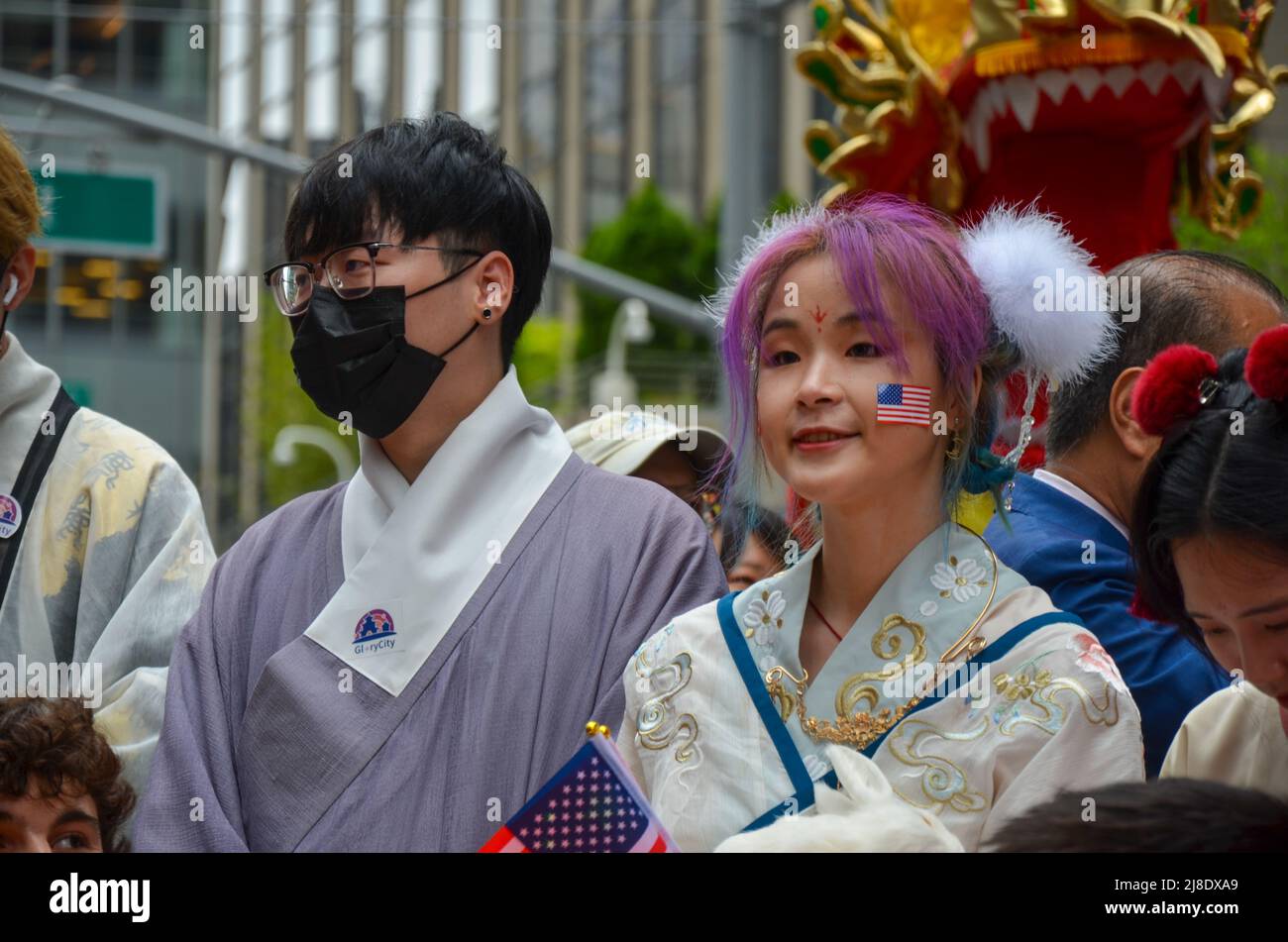 Un partecipante è visto indossare abiti tradizionali cinesi sulla Sixth Avenue, New York City per celebrare la prima Islande asiatica americana e del Pacifico Foto Stock