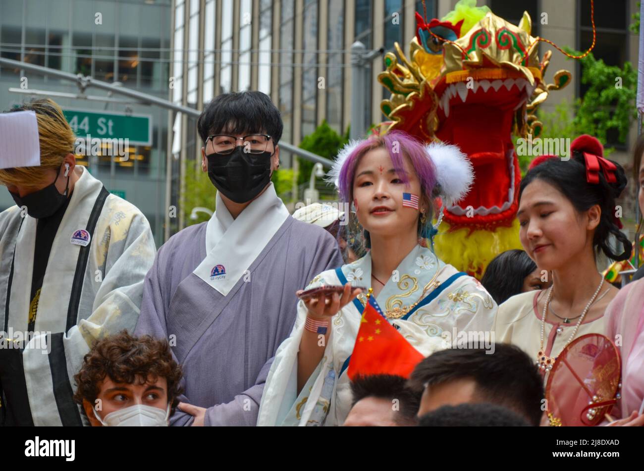 Un partecipante è visto indossare abiti tradizionali cinesi sulla Sixth Avenue, New York City per celebrare la prima Islande asiatica americana e del Pacifico Foto Stock