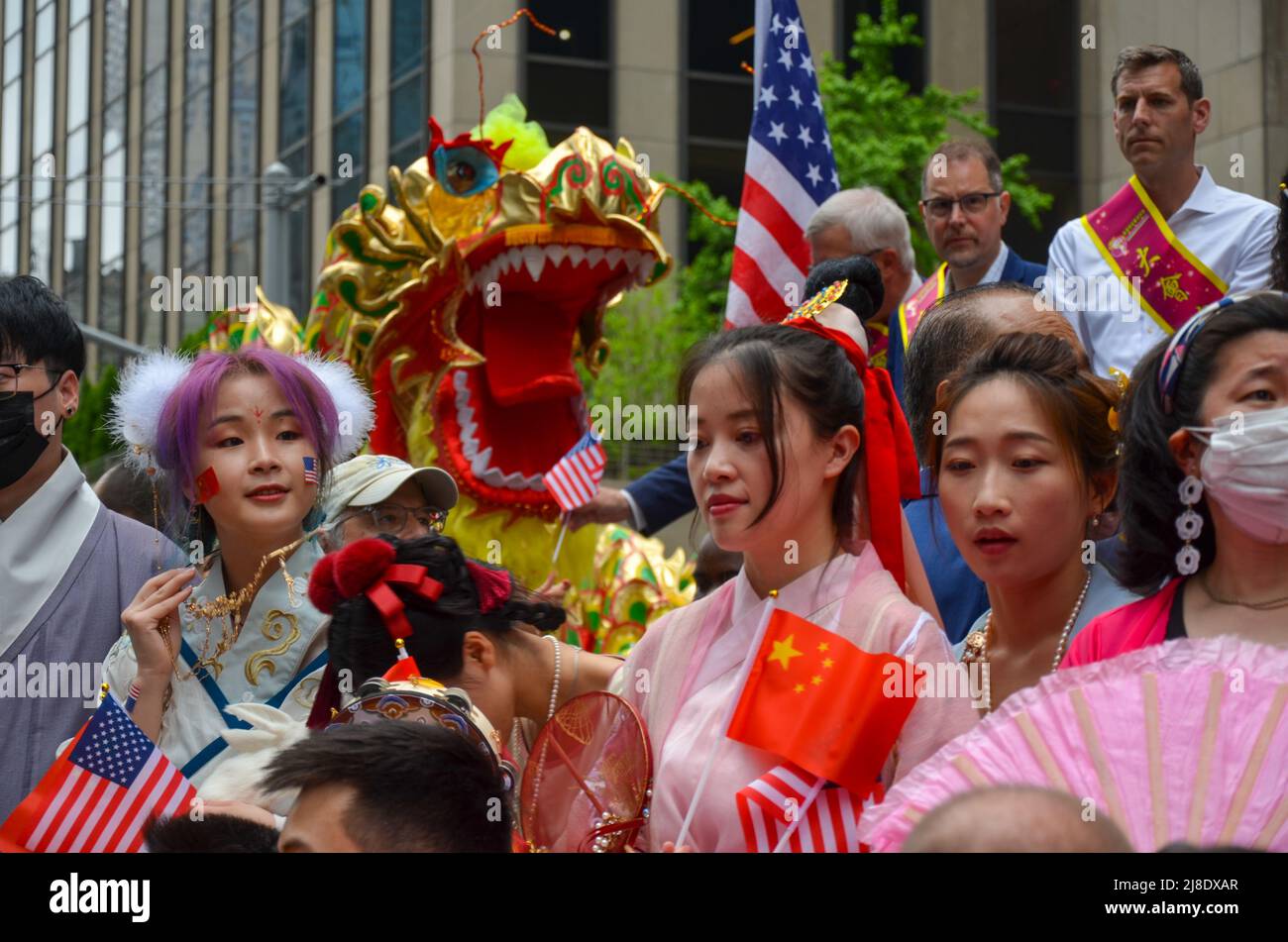 Un prticipant è visto tenendo bandiera cinese sulla Sixth Avenue, New York City per celebrare il primissimo asiatico americano e Pacifico Islander Cultural e. Foto Stock
