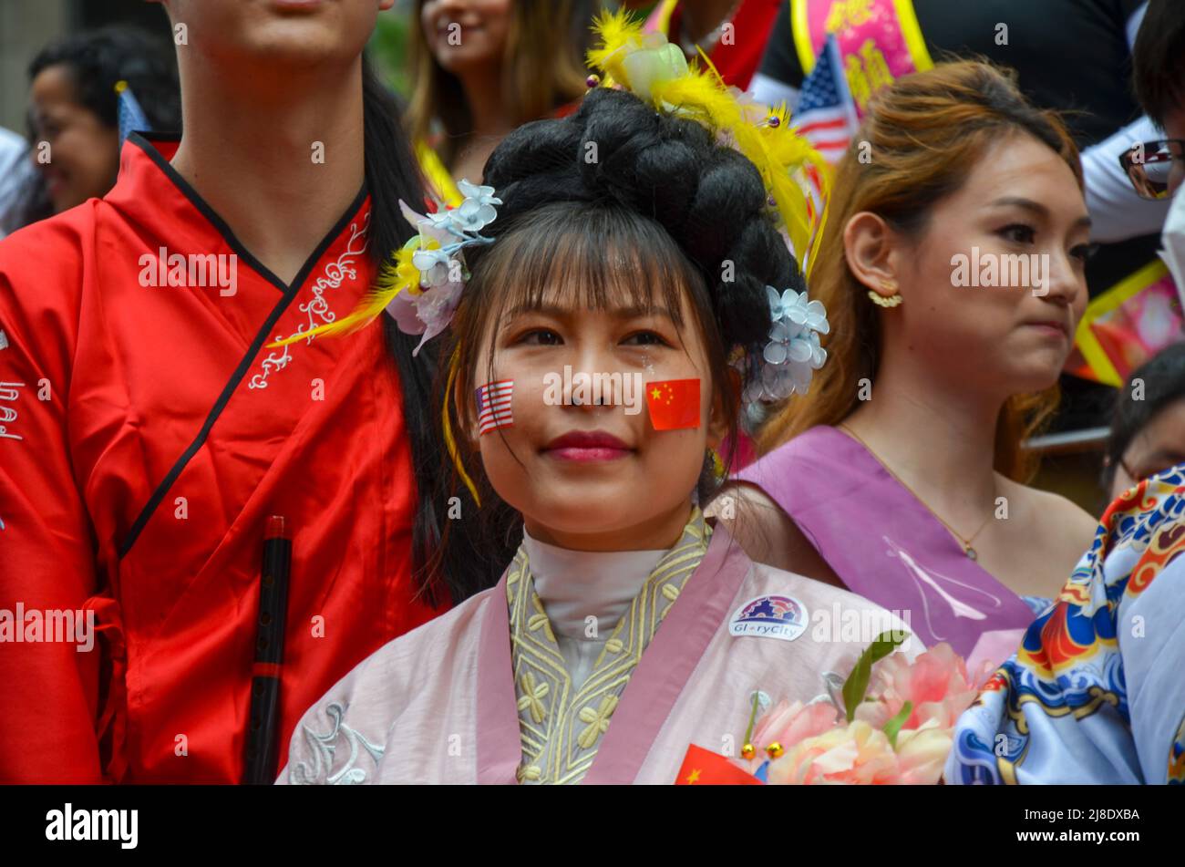 Un participnt è visto indossare gli Stati Uniti e l'adesivo della bandiera cinese sulla Sixth Avenue, New York City per celebrare il primissimo americano asiatico e. Foto Stock