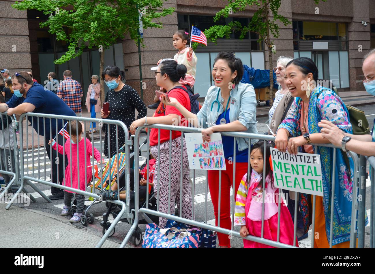 Gli spettatori sono visti tenendo delle indicazioni su Sixth Avenue, New York City per celebrare il primissimo Asian American e Pacific Islander Cultural and Heritage Foto Stock