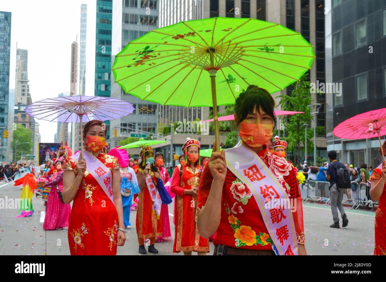 I partecipanti che detengono ombrelloni si sfilano lungo la Sesta Avenue durante la prima parata culturale e del patrimonio dell'Islander dell'Asia americana e del Pacifico a New Y Foto Stock