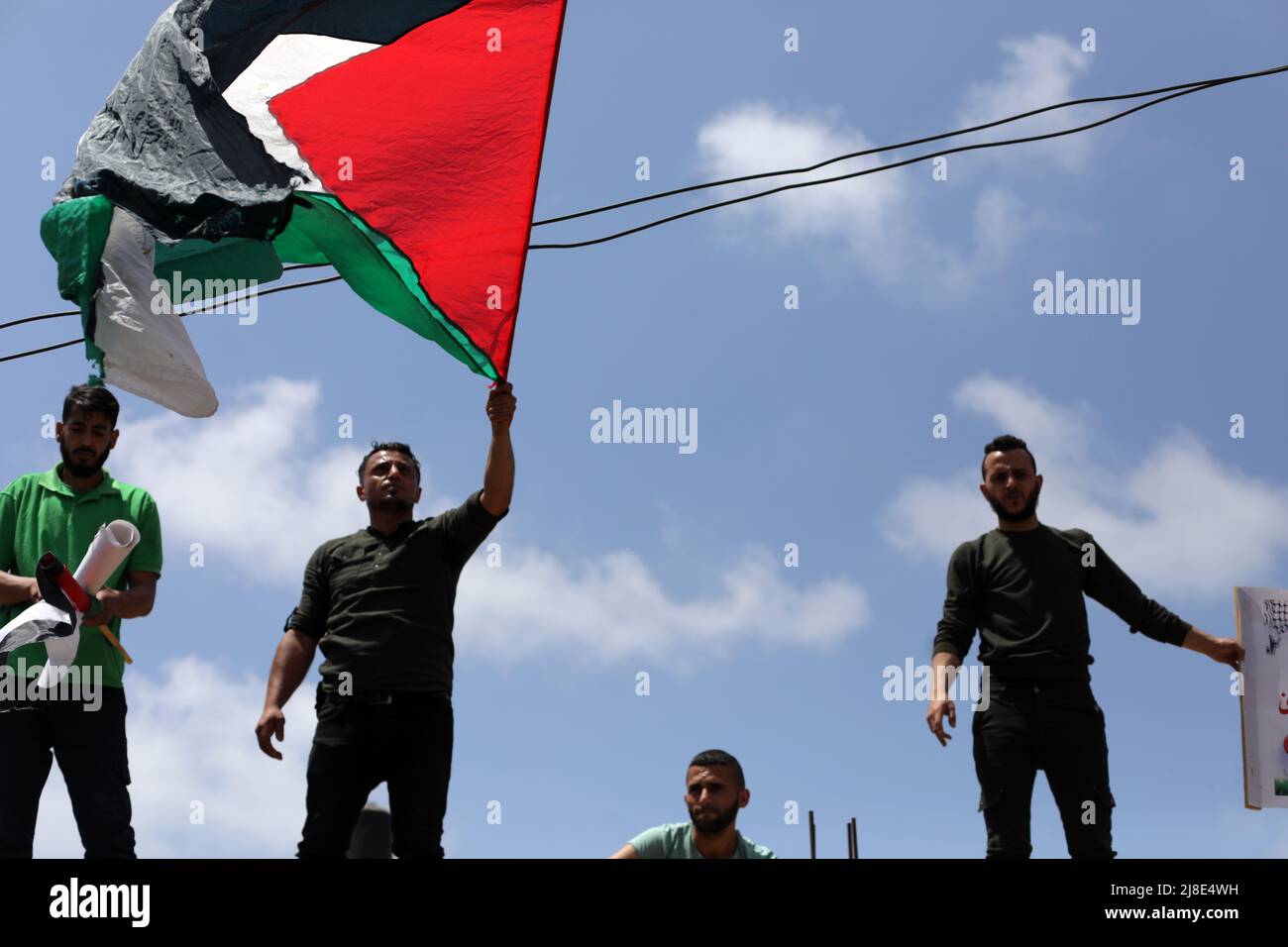 Città di Gaza, Palestina. 15th maggio 2022. I palestinesi ondeggiano le loro bandiere nazionali durante un raduno che segna il 74h° anniversario di ciò che i palestinesi chiamano "Nakba", o "catastrofe", riferendosi al loro sradicamento nella guerra contro la creazione di Israele del 1948, di fronte agli uffici dell'UNESCO a Gaza City. Credit: Majority World CIC/Alamy Live News Foto Stock