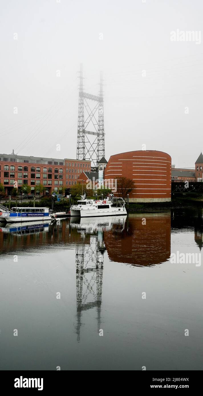 NORWALK, CT, USA - 15 MAGGIO 2022: Bella nebbia mattutina vicino al centro con acquario marittimo, barche e ponte ferroviario Foto Stock