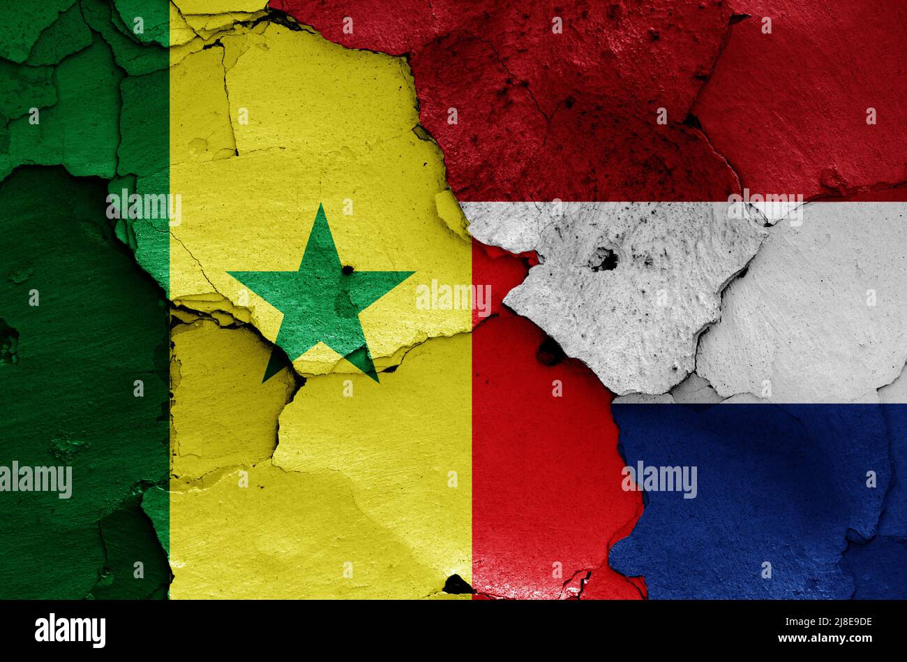 Bandiere del Senegal e dei Paesi Bassi dipinte su muro incrinato Foto Stock