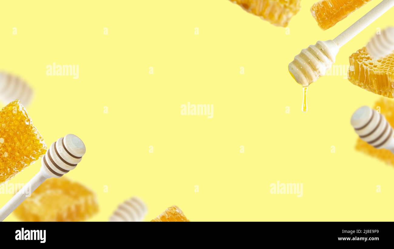 Una serie di peperoni al miele con goccia di miele e pezzi di nido d'ape galleggianti su sfondo giallo. Composizione concettuale del miele con spazio per il testo Foto Stock