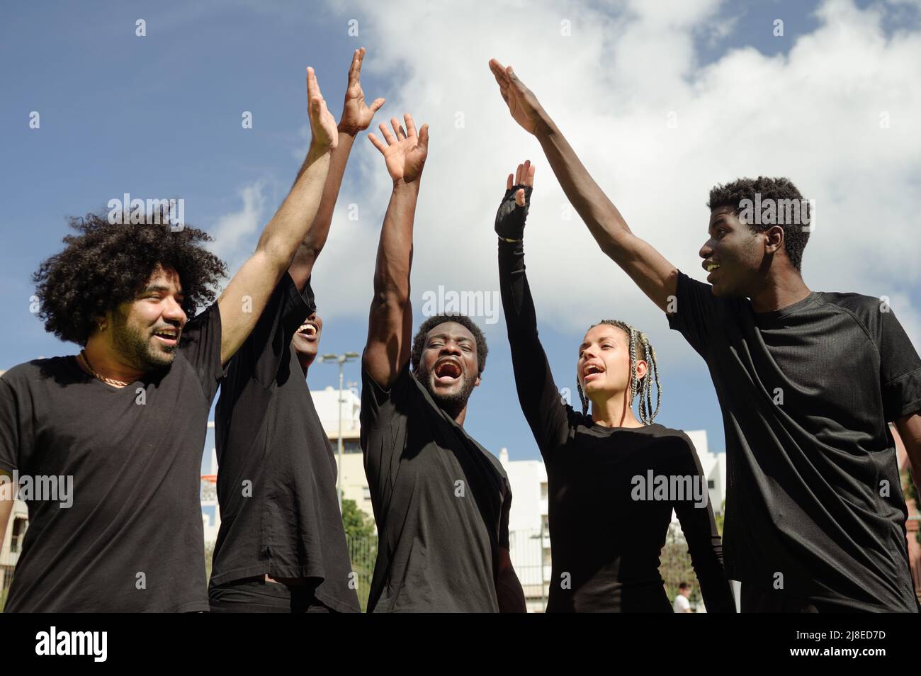 Allegra squadra di pallacanestro afroamericana che dà cinque alti in città Foto Stock