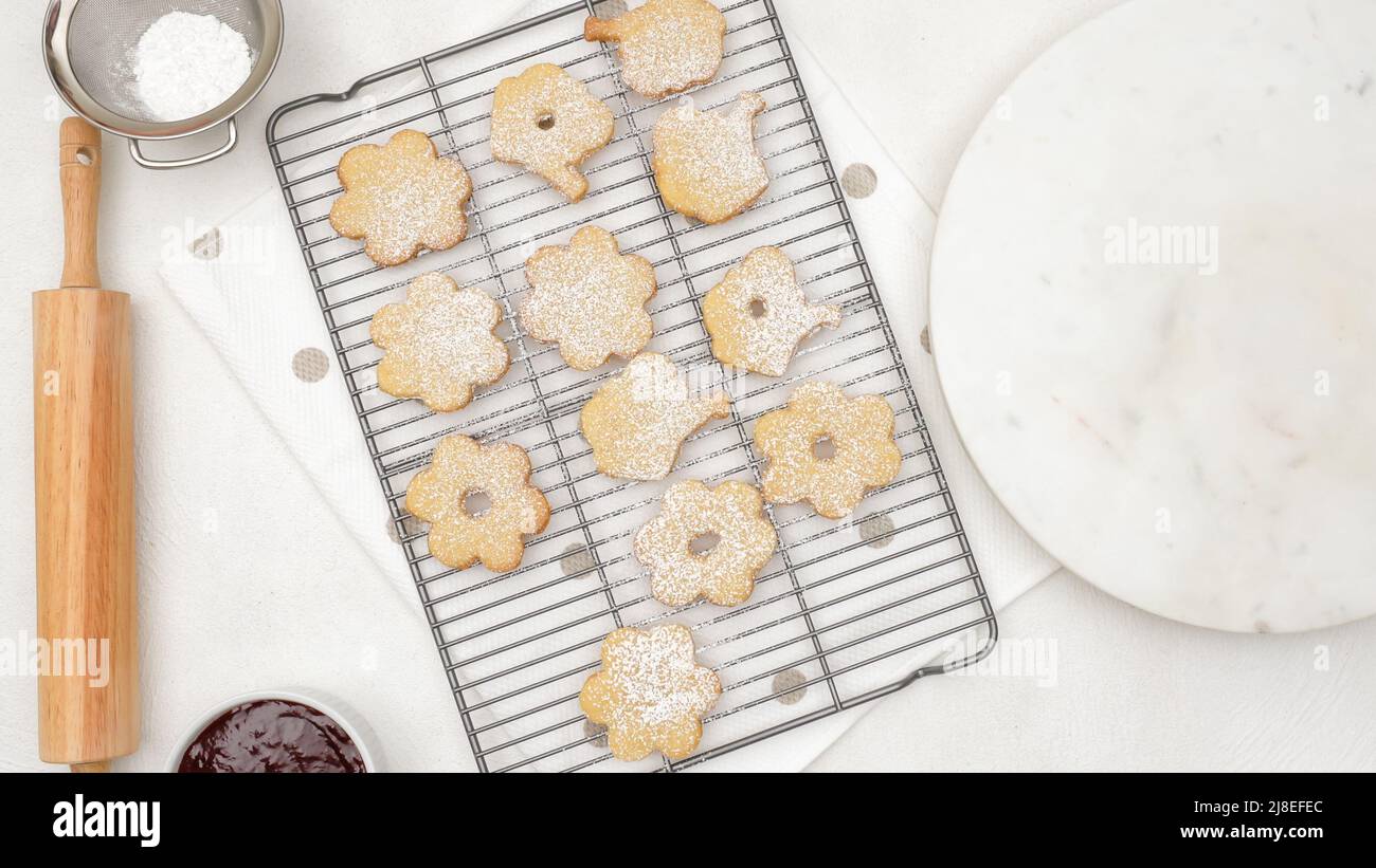 Biscotti appena sfornati sulla griglia di raffreddamento. Biscotti con aggiunta di zucchero in polvere, primo piano cottura, piatto. Foto Stock