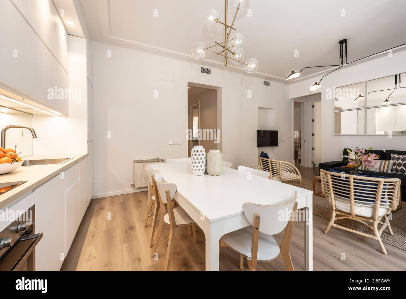 Soggiorno, cucina, sala da pranzo in appartamento arredato con mobili in legno bianco Foto Stock