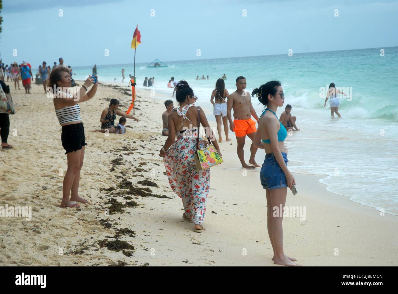 Turisti sulla spiaggia di Puka Shell, Boracay, i Visayas, Filippine, Asia sudorientale. Foto Stock