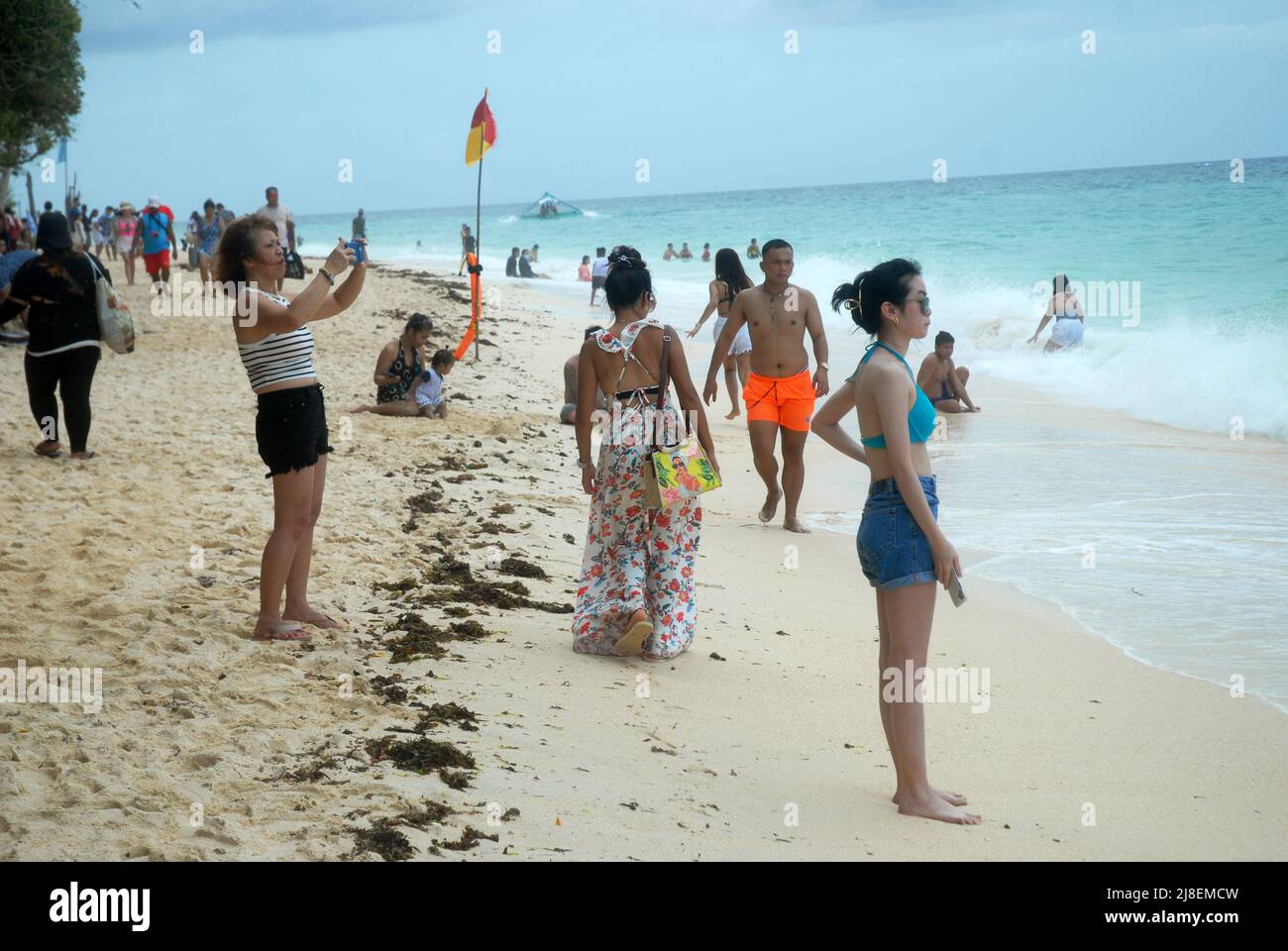 Turisti sulla spiaggia di Puka Shell, Boracay, i Visayas, Filippine, Asia sudorientale. Foto Stock