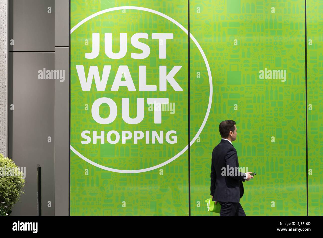 Un uomo acquirente fuori dal negozio di alimentari amazon 'amazon Just walk out shopping sign' Londra Inghilterra Regno Unito Foto Stock