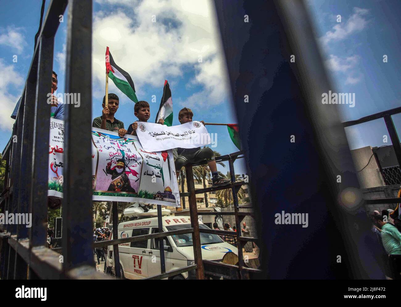 I palestinesi ondano bandiere nazionali mentre marciano durante un raduno che segna il 74th° anniversario della 'Nakba' o 'catastrofe', nella città di Gaza. I palestinesi e gli israeliani arabi a Gaza commemorano il 74th° anniversario della Nakba Day e condannano l'assassinio del giornalista palestinese-americano Shireen Abu Akleh da parte delle forze israeliane. Il termine 'Nakba? Significa 'catastrofe? In arabo e si riferisce alla pulizia etnica sistematica di due terzi della popolazione palestinese all'epoca da parte dei paramilitari sionisti tra il 1947-1949 e la distruzione quasi totale della società palestinese. Foto Stock