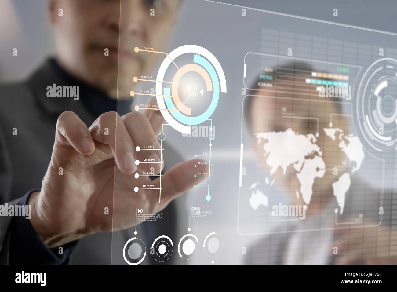 Due uomini d'affari asiatici che interagiscono con il futuristico touchscreen virtuale mentre analizzano i dati delle informazioni aziendali Foto Stock