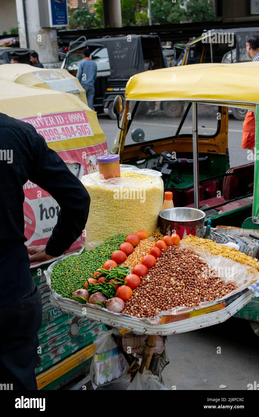 Cibo di strada indiano tradizionale esposto in vendita in un affollato mercato pubblico. Foto Stock