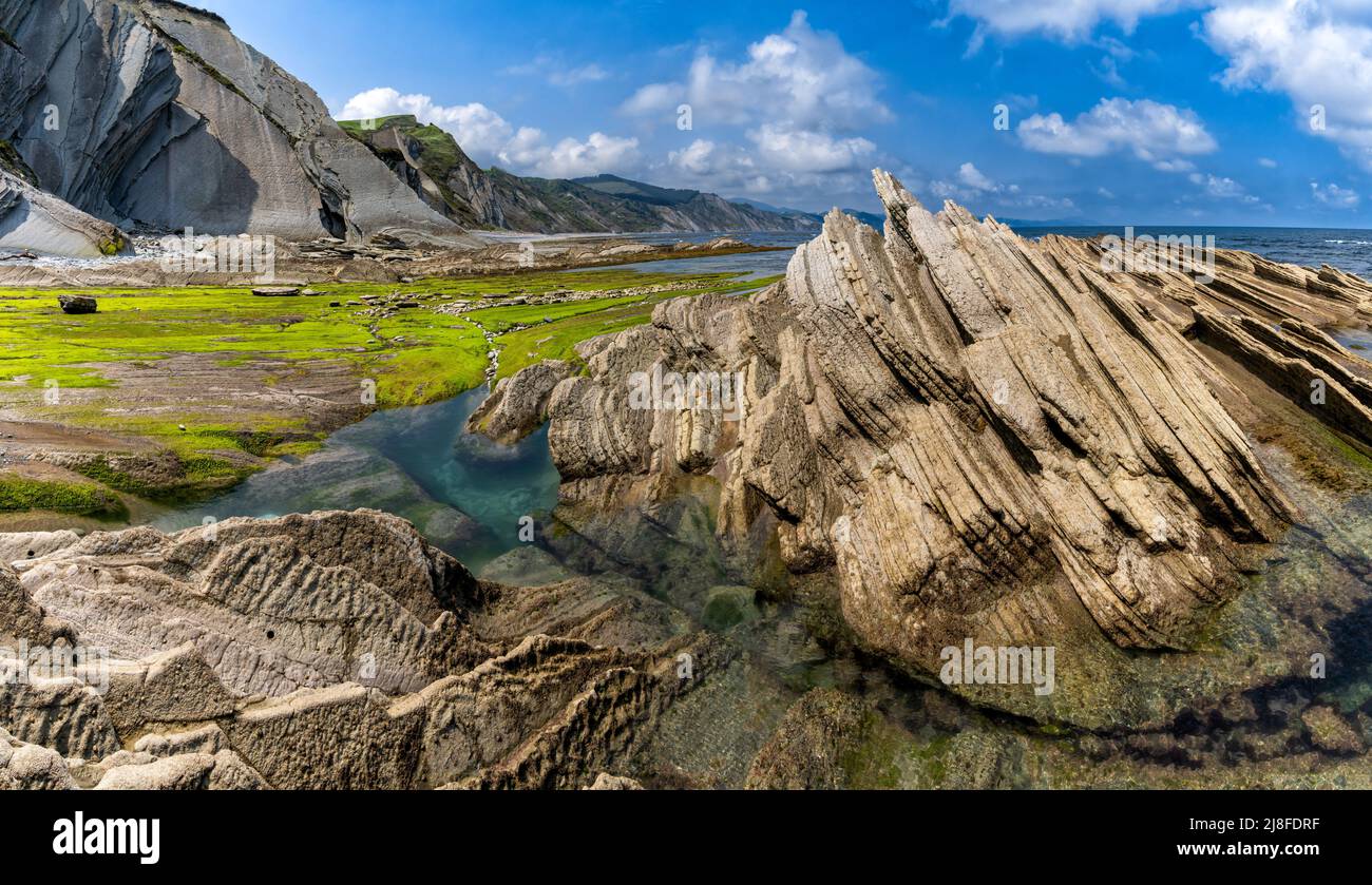 Una vista delle formazioni rocciose di Flysch e scogliere con piscine di marea sulla costa dei Paesi Baschi vicino a Zumaia Foto Stock