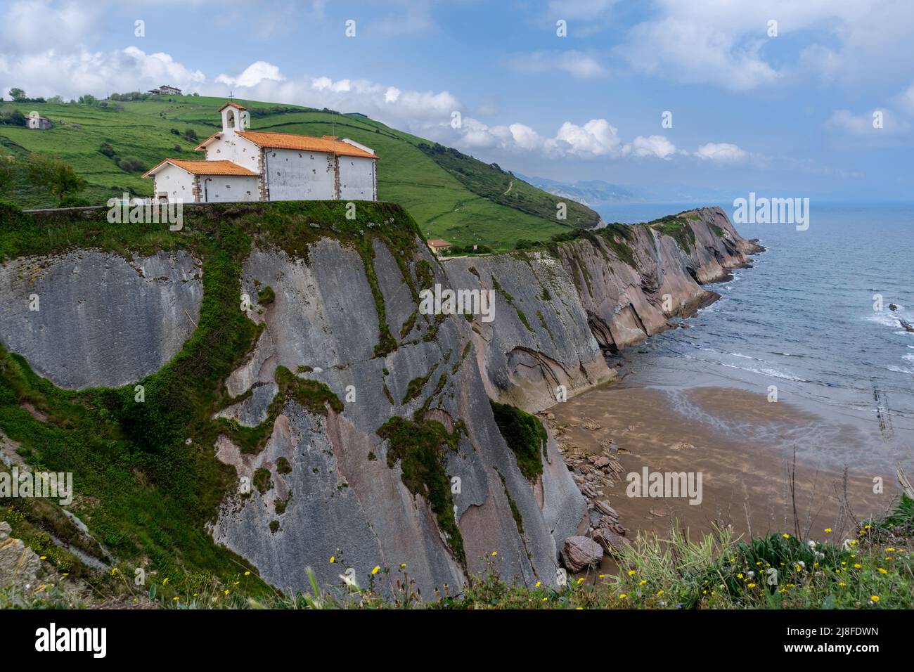 Vista della cappella dell'Hermitage di San Telmo e delle formazioni rocciose di Flysch sulla costa dei Paesi Baschi a Zumaia Foto Stock