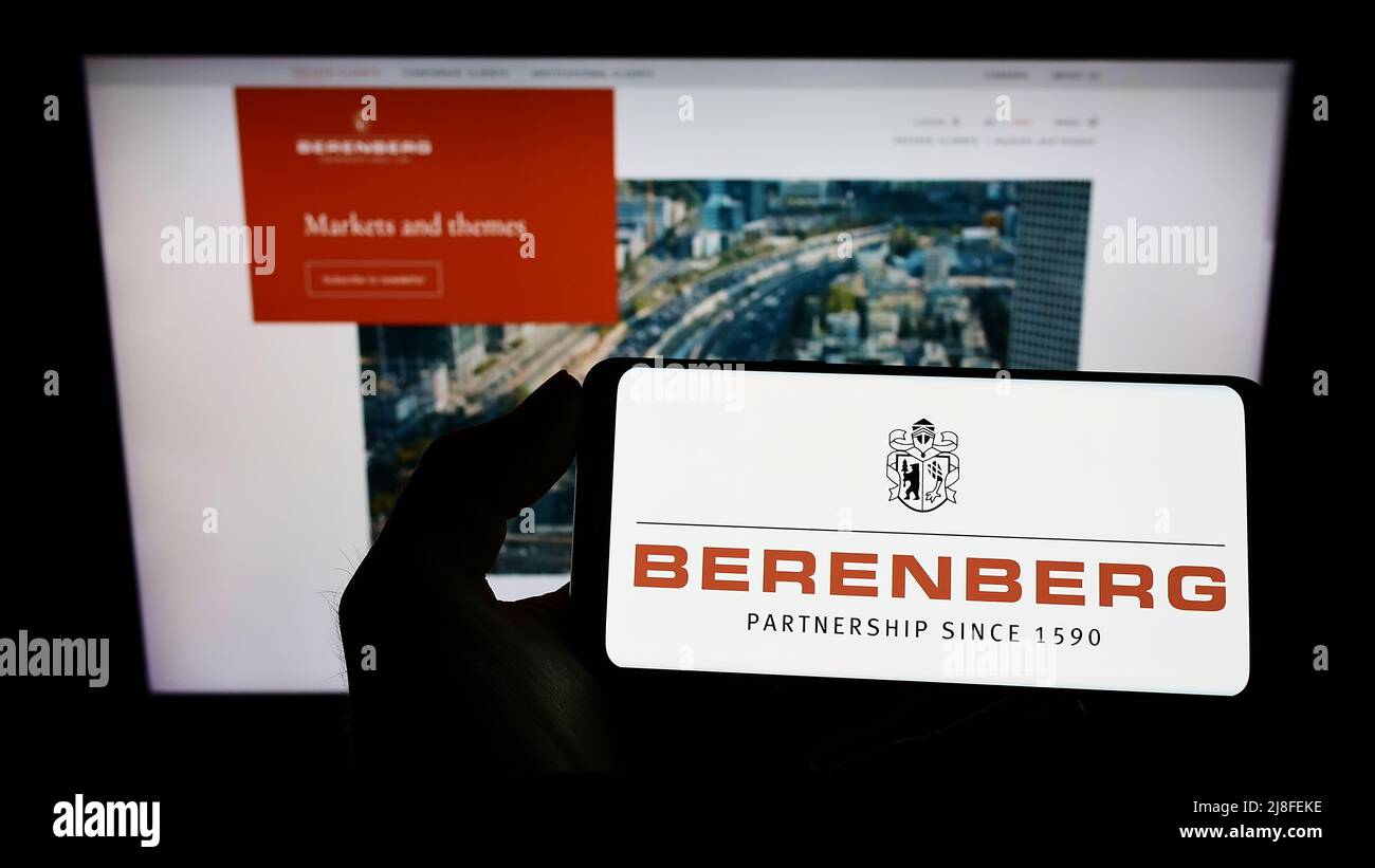 Persona che tiene il cellulare con il logo della banca tedesca Joh. Berenberg, Gossler Co. KG sullo schermo di fronte al sito web aziendale. Mettere a fuoco sul display del telefono. Foto Stock