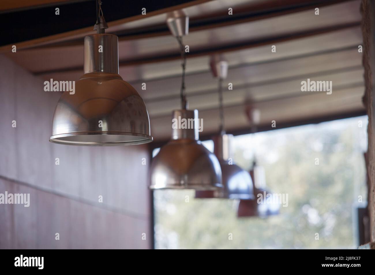 Linea di lampade a sospensione industriali. Messa a fuoco selettiva Foto Stock