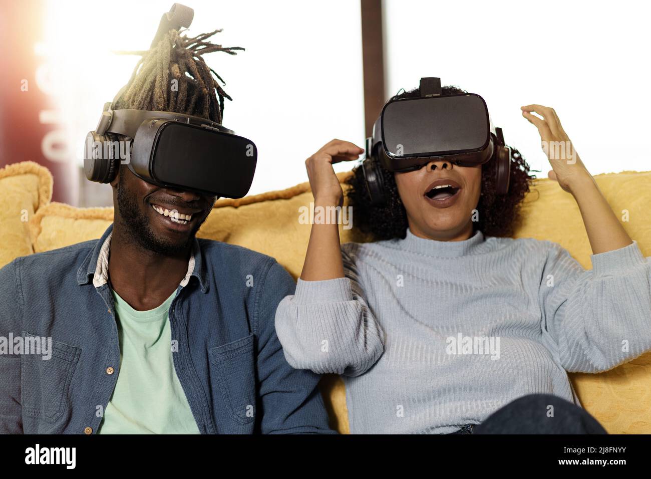 Stupito un paio di giovani multietnici che si divertono a giocare ai videogiochi con 360 googles vr 3D: Il concetto di stile di vita degli amici che si divertono con la tecnologia g Foto Stock