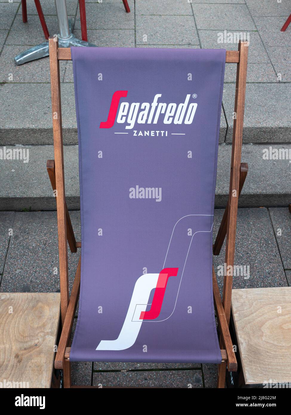 Friburgo in Breisgau, Germania - 13 aprile 2022: Lettino solare con cartello pubblicitario della compagnia di caffè Segafredo Zanetti Foto Stock