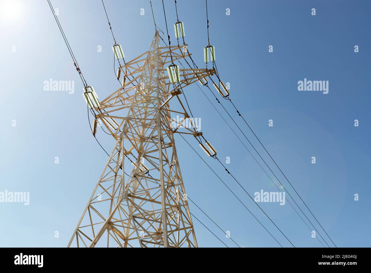 Tralicci e fili di una linea elettrica contro il cielo blu Foto Stock